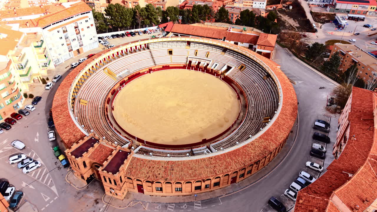 Prospettiva aerea diretta di un'arena da corrida tradizionale che mostra l'arena di sabbia, le file di posti a sedere e la struttura d'ingresso in mattoni. Vista aerea dall'alto di un'arena da corrida vuota