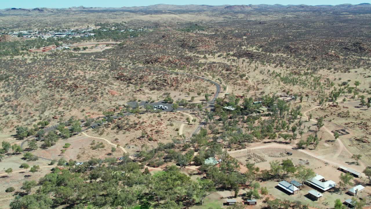 Reversing aerial view of the Telegraph Station and dry Todd River, north of Alice Springs, Mparntwe, Northern Territory, Australia. August 2022.