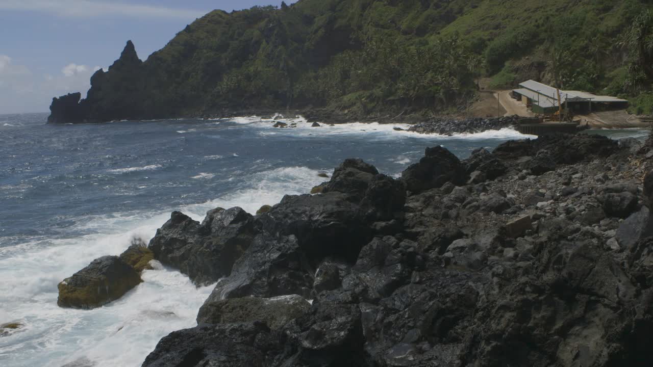Pitcairn Island dock with waves crashing on the rocks of the shore