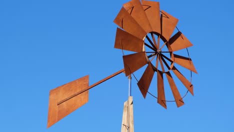 old air windmill on a background of blue sky.