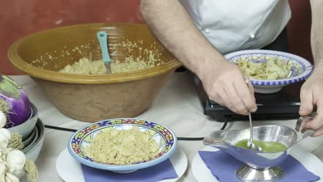 Italian chef cooks cous cous in vintage style kitchen hands closeup, add sauce