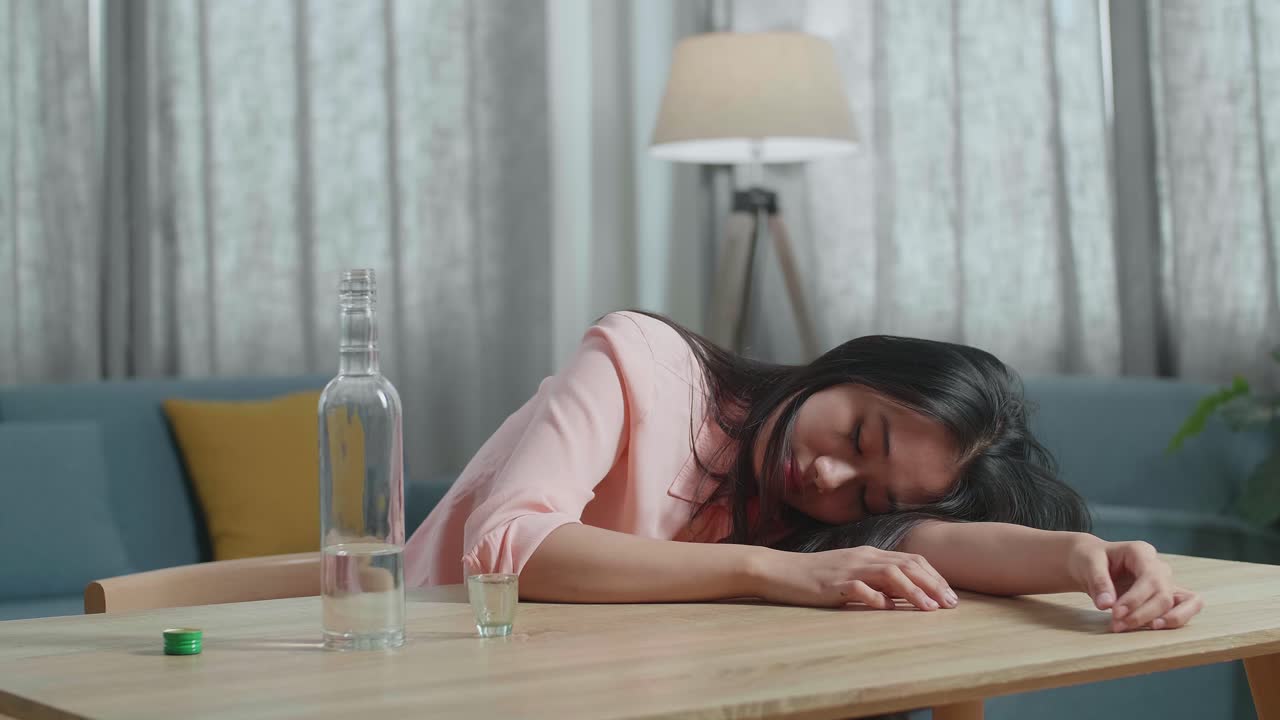 술에 취한 아시아 여성이 집에서 잠을 자고 있습니다.