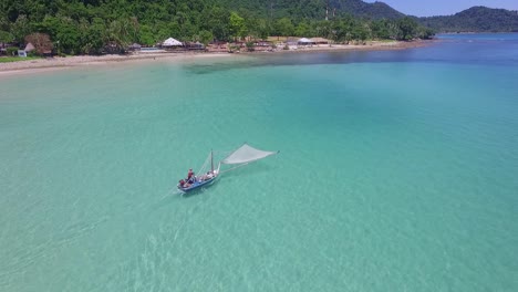 static aerial shot of a traditional shrimp fisherman on small wooden boat in thailand with coastline