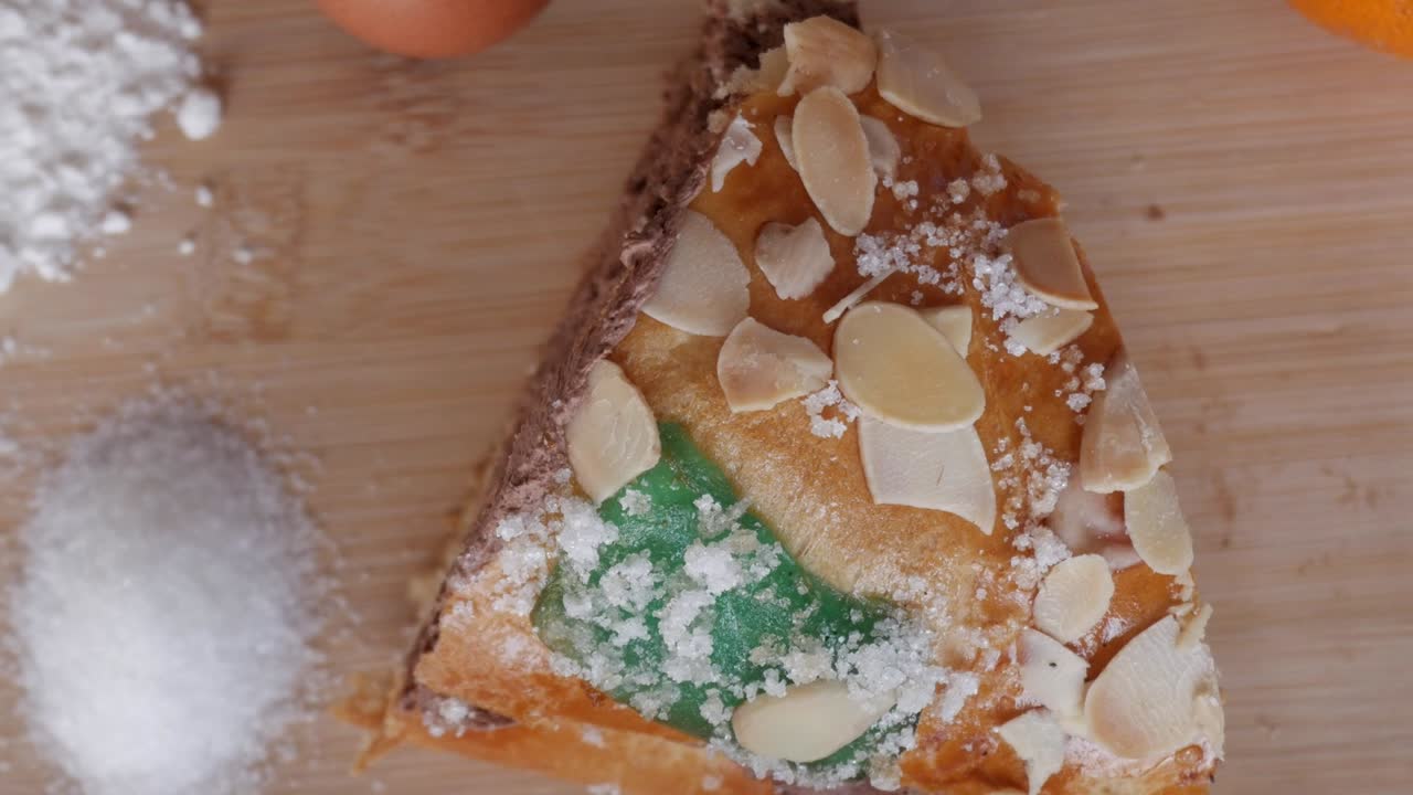 Traditional Rosco de Reyes with almonds and sugar on wooden board