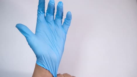 putting on blue medical gloves