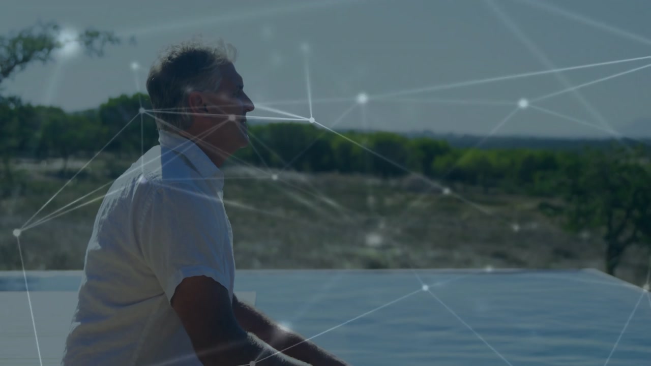 Camera pulling back revealing man at poolside interacting with network overlay for tech demo