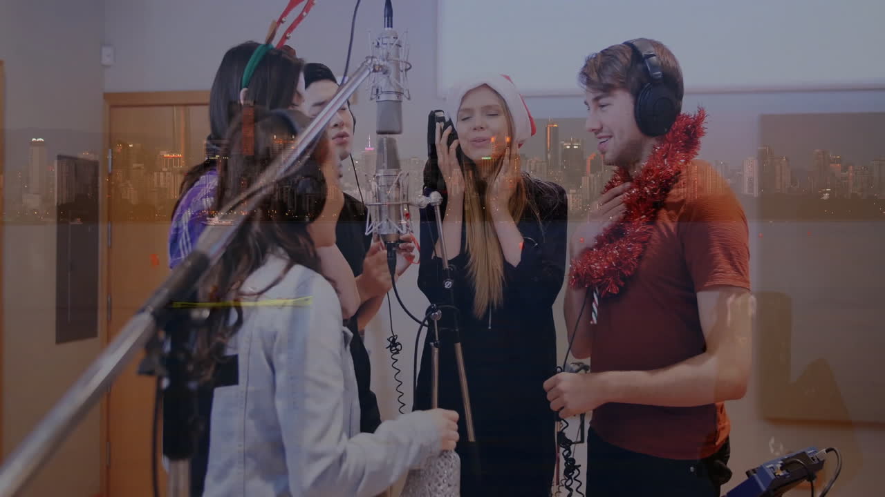 Group of five creators singing festive music track at studio mic, showing audio waveforms