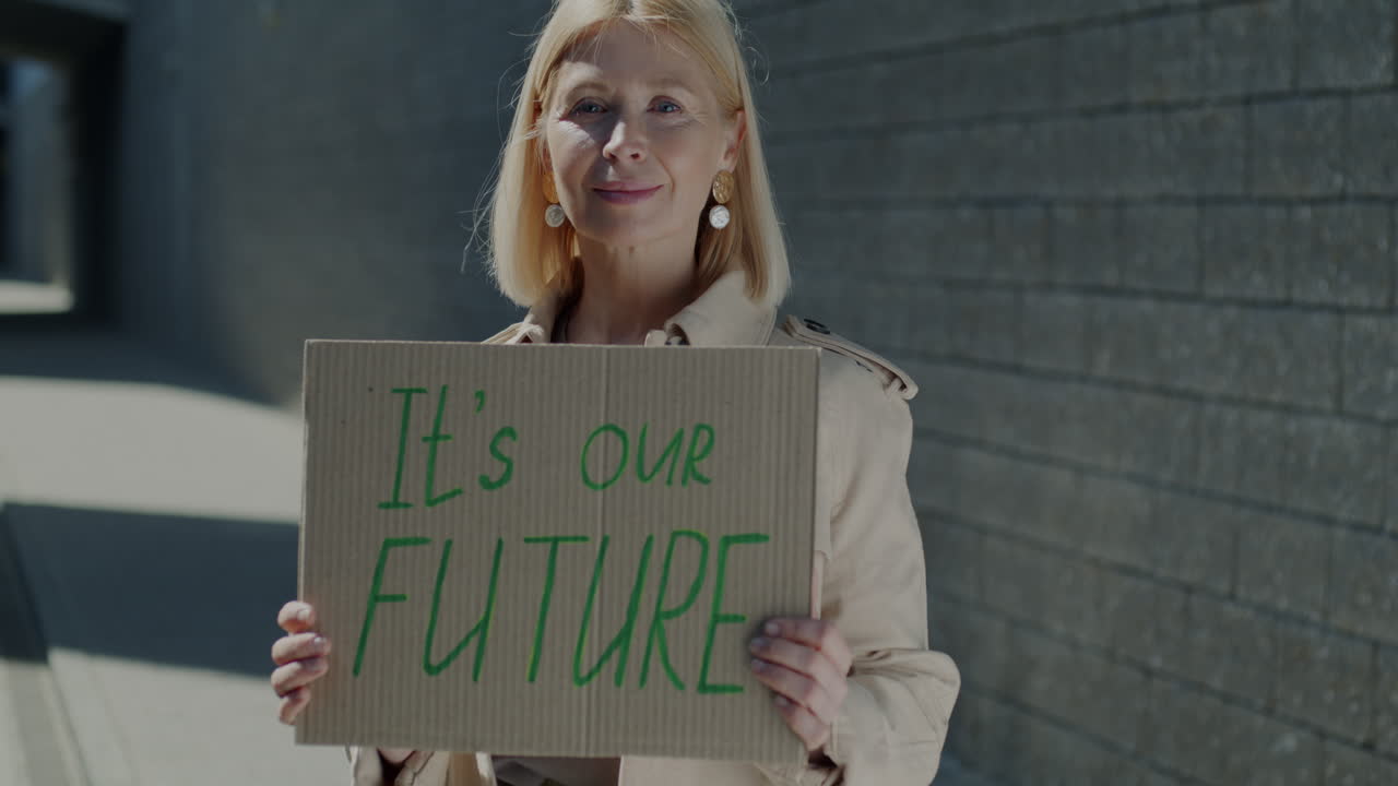 Woman Holding Sign Saying 'It's Our Future'