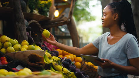 Frau-Mit-Digitalem-Tablet-Arbeitet-Am-Stand-Für-Frisches-Obst-Und-Gemüse-Auf-Dem-Markt-Und-Prüft-Den-Lagerbestand