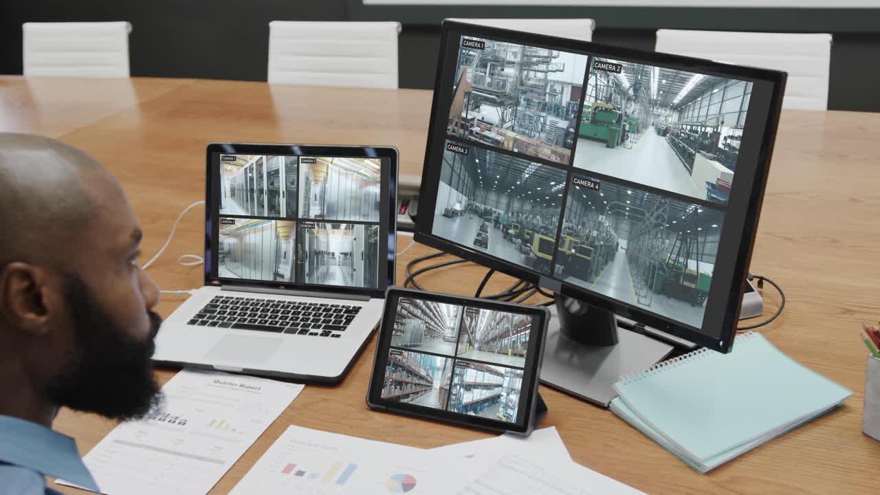 oficial de seguridad afroamericano viendo las vistas de las cámaras de cctv en pantallas de computadora, cámara lenta