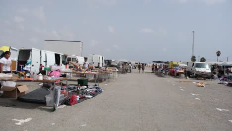 a lively flea market buzzes with activity as shoppers browse through an array of old household items and reusable goods, creating a vibrant, nostalgic atmosphere.