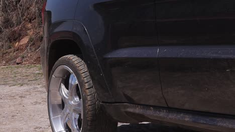 close up of black van arrives in dry and arid place