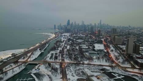 drone shot rising away from the lincoln park, misty, winter evening in chicago, usa - pull back, drone shot