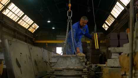 worker using overhead crane in foundry workshop 4k