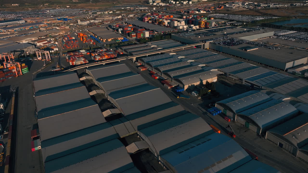 Aerial shot of warehouses at Luka Koper port, Slovenia. Shows industrial buildings, storage facilities, and port infrastructure from above, highlighting logistics and maritime operations