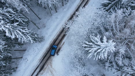 Blaues-Auto,-Das-Im-Winter-In-Deby,-Polen,-Entlang-Der-Straße-Fährt