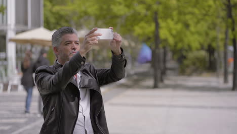 Hübscher-Reifer-Mann,-Der-Sein-Smartphone-Auf-Der-Straße-Benutzt