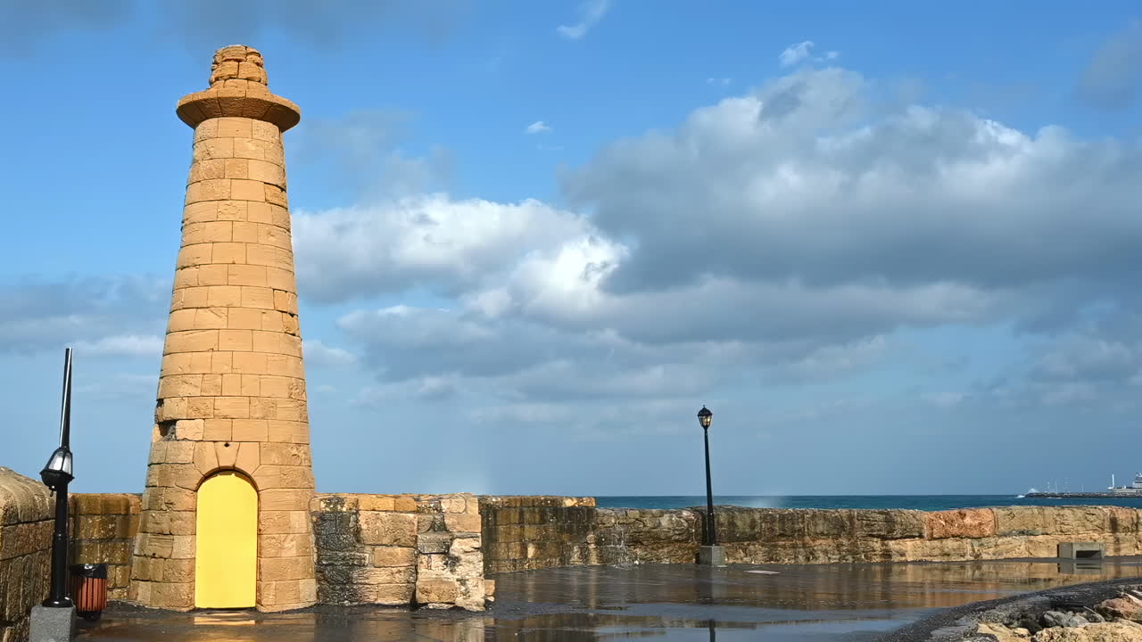 Water splashing over the Girne Historic Lighthouse on the shore in Kyrenia, Cyprus