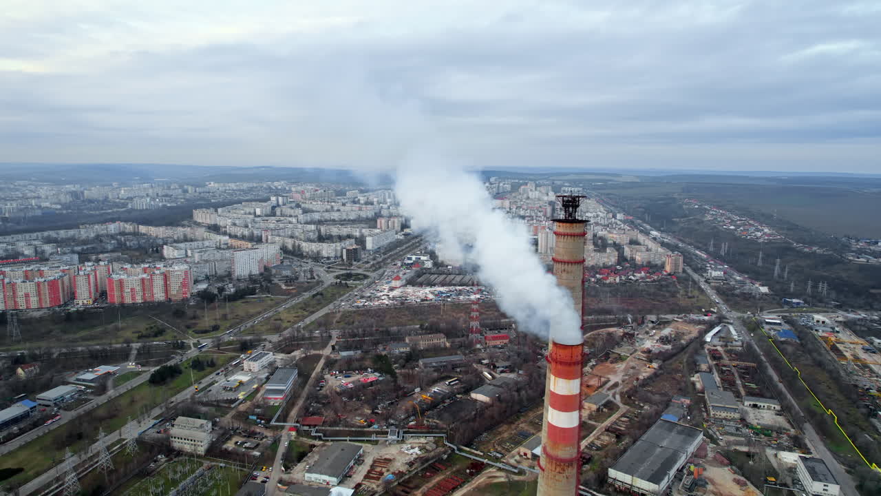 Aerial drone view of thermal power plant in Chisinau at cloudy weather, Moldova. View of pipes with felling steam, cityscape