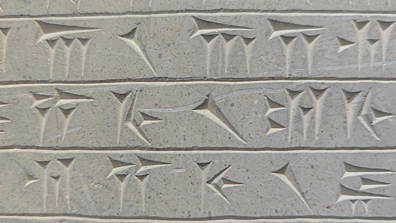 Primo piano di antiche iscrizioni cuneiformi scolpite nella pietra
