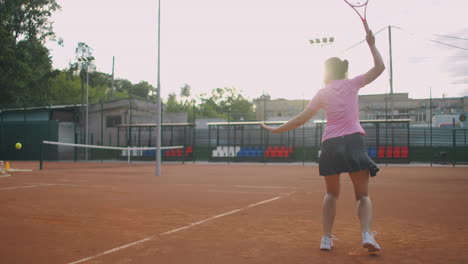 Seitenansicht-Einer-Jungen-Kaukasischen-Frau,-Die-Auf-Einem-Platz-Tennis-Spielt-Und-In-Zeitlupe-Einen-Ball-Zurückschlägt