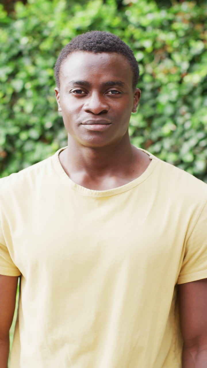 video vertical del retrato de un feliz hombre afroamericano en el jardín