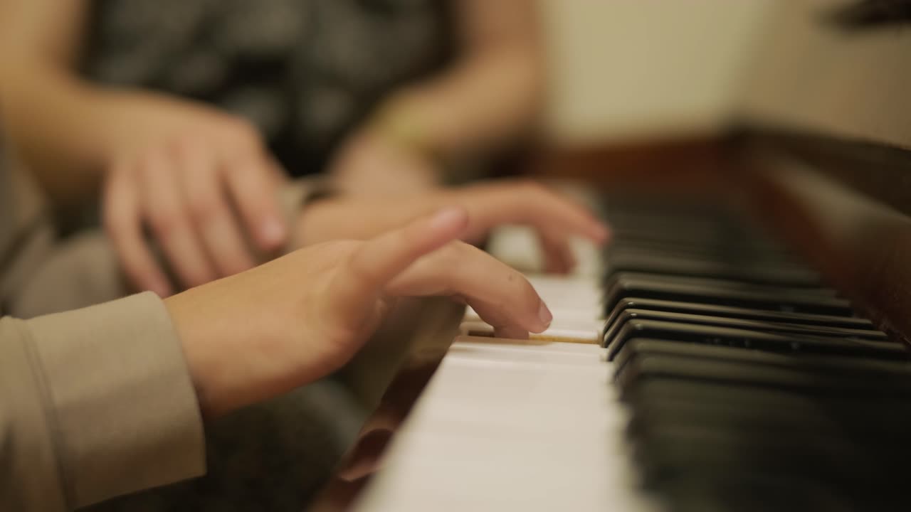 primer plano de las manos de un niño tocando el piano.