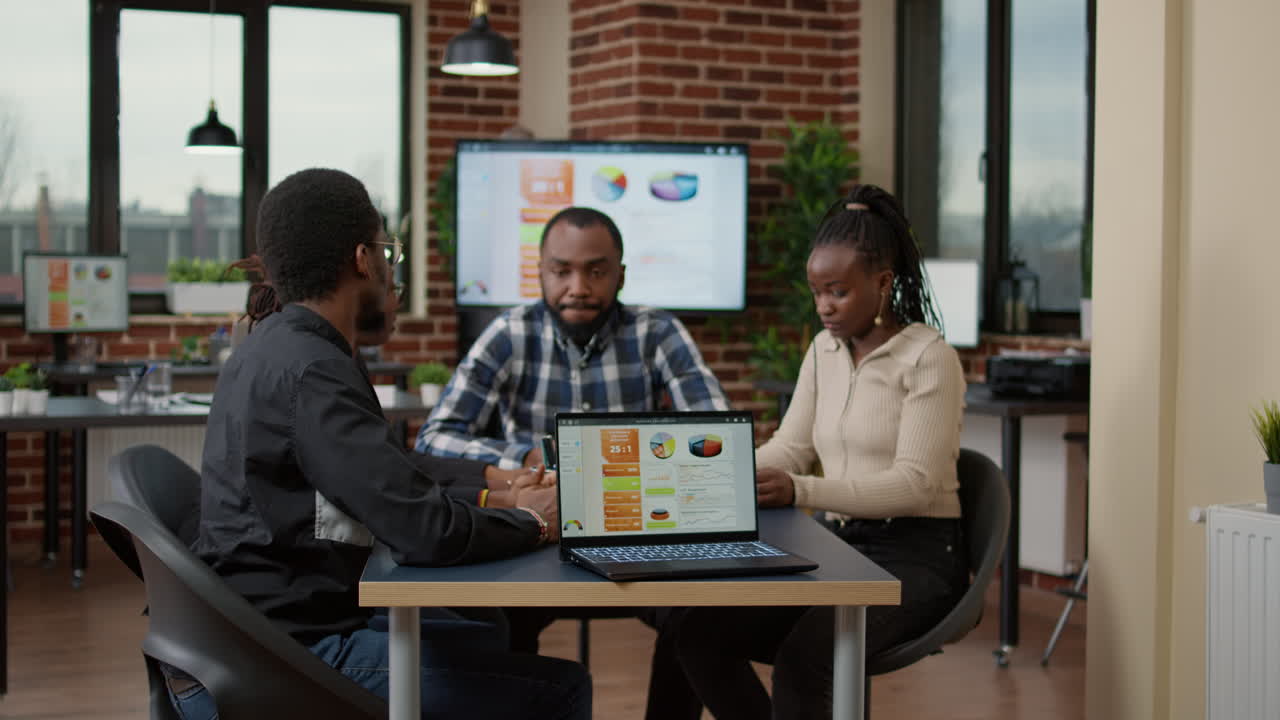 African american team of people using financial charts to work