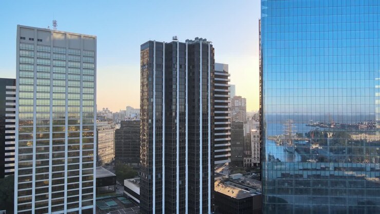Dolly aereo a destra del quartiere di Puerto Madero riflesso sui grattacieli in vetro al tramonto, Buenos Aires
