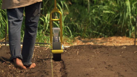 Poor-farmer-worker-using-a-seeder-to-start-his-new-business-in-the-field,-hard-work-concept