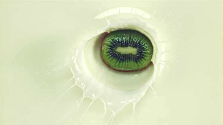 Kiwi Slice Dropping into Milk in Slow Motion