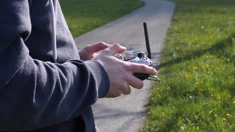 close-up hands of a young man flying a fpv racing drone in the fields