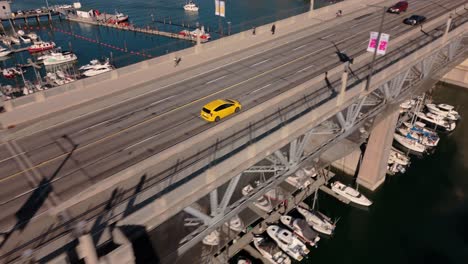 aerial over burrard st bridge tracking yellow taxi cab into downtown vancouver - autumn day