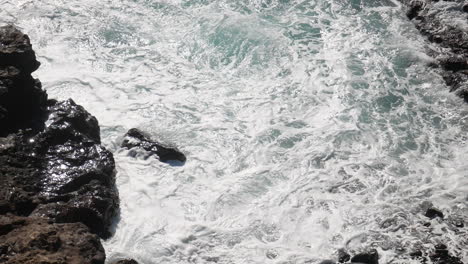 Waves-and-sea-ocean-swell-crashing-onto-rocks-on-the-coast-close-up