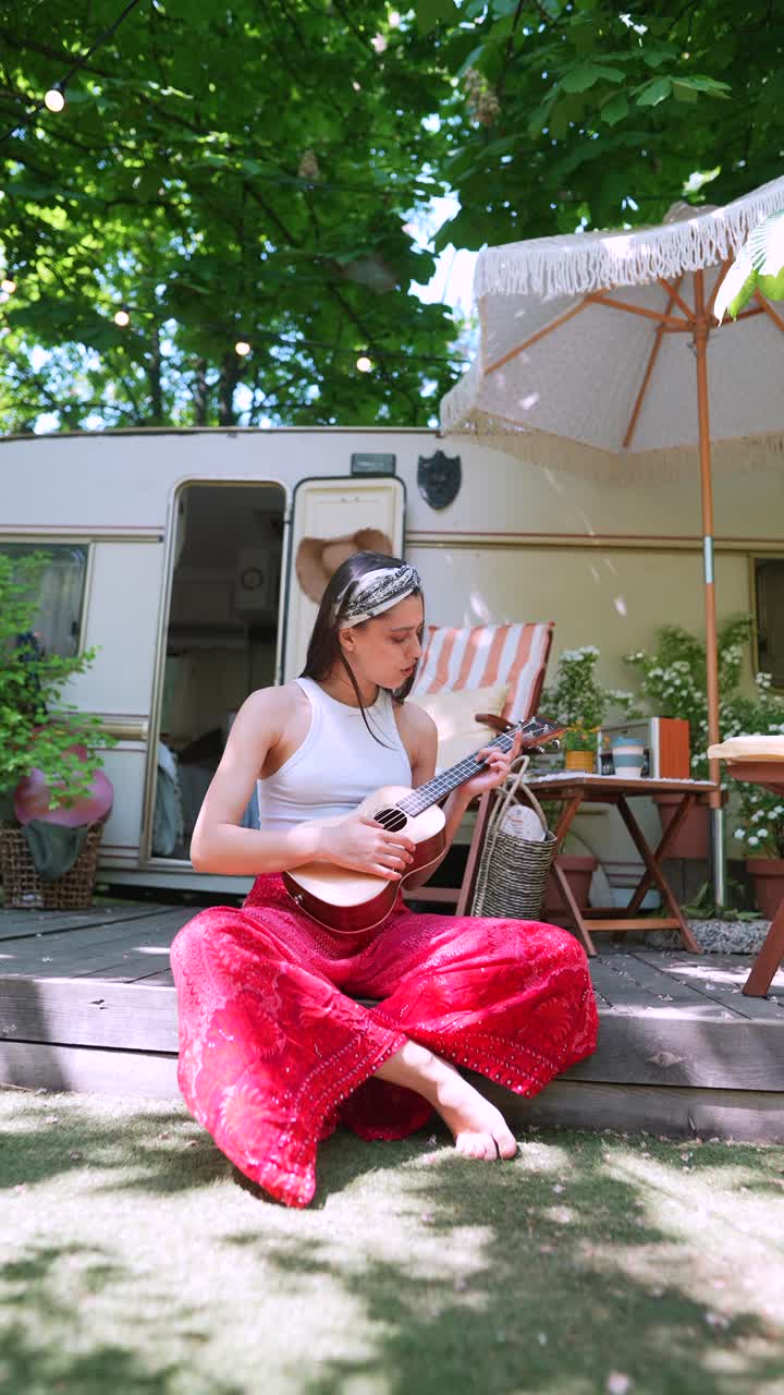 Donna che suona l'ukulele in campeggio
