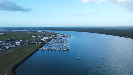 A-high-revealing-drone-view-of-multiple-boats-docked-in-a-protected-harbor-located-in-the-town-of-Bargara-Bundargerg-Queensland-Australia