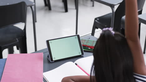 una joven asiática con cabello largo y negro levanta la mano en el aula, copia el espacio