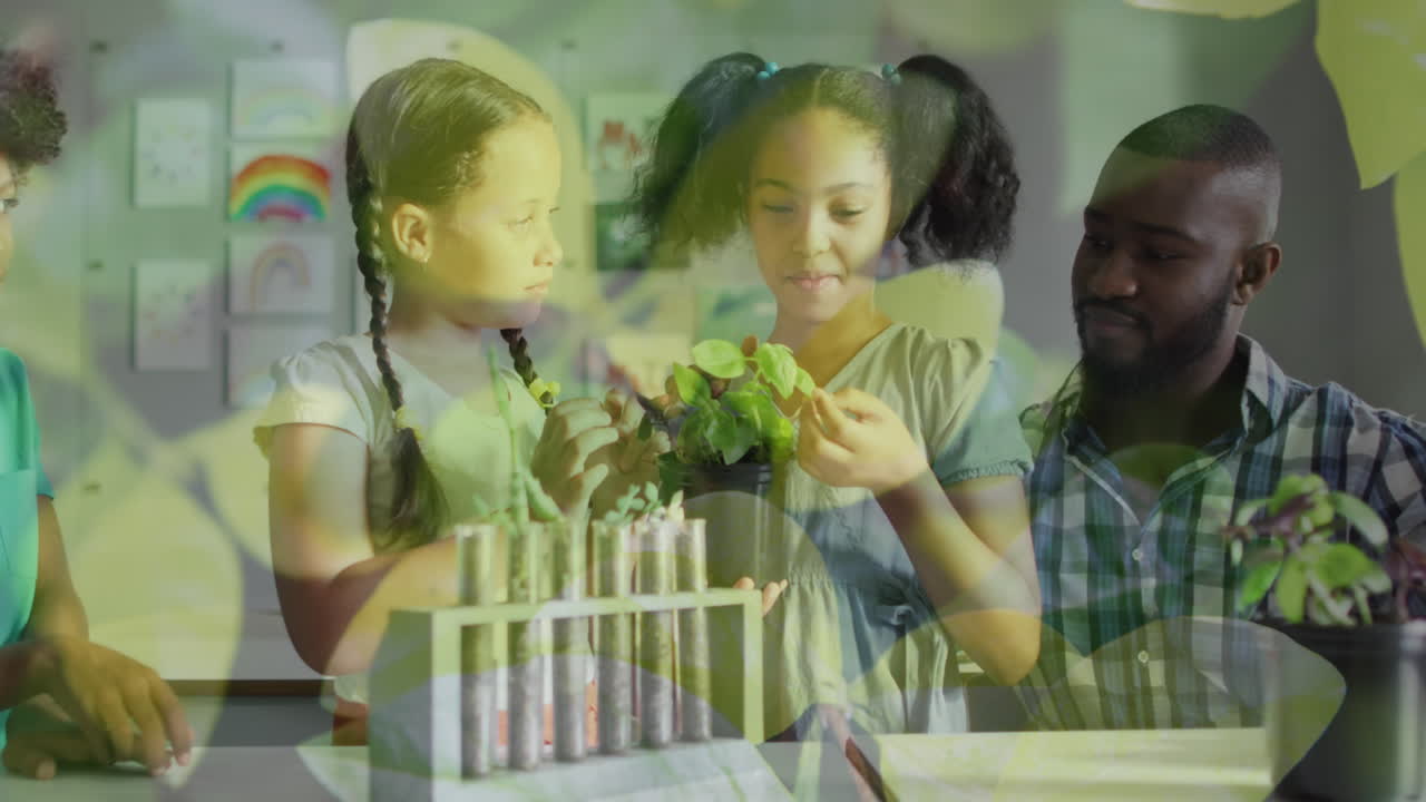 Animation of leaves over happy diverse male teacher and schoolgirls studying plants in biology class