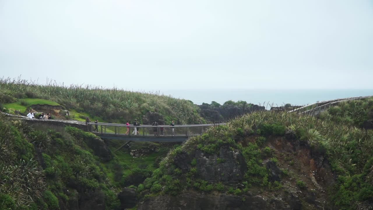 Group of tourists on bridge at Punakaiki Pancake Rocks, New Zealand