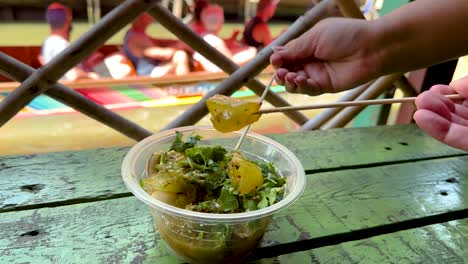 sampling spicy squid dish at bangkok's floating market