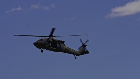 view of sikorsky uh-60 black hawk flying in air against blue skies