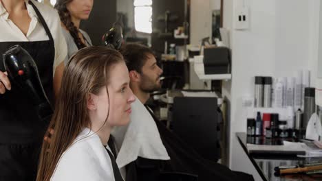 Two-hairdresser-blow-drying-their-client-hair