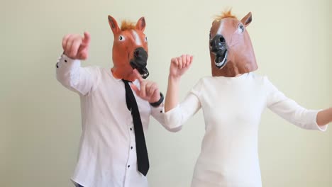 office workers in carnival horse masks they dance and have fun during the working day office workers in carnival horse masks they dance and have fun during the working day happy people