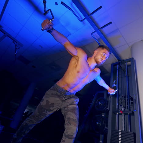 athlete with strong body doing work out pushing up excercise in gym. view from the bottom. blue light filter.