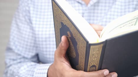 hombre sosteniendo el libro sagrado corán de cerca