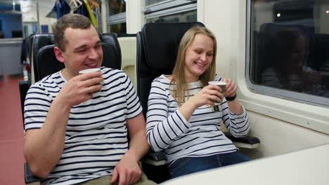 man and woman drinking tea in train