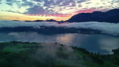 Amanecer-Sobre-El-Brumoso-Lago-Attersee-En-Austria-Con-Un-Pueblo-En-La-Orilla---Empuje-Aéreo