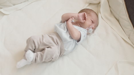 cute newborn baby lying on bed and crying