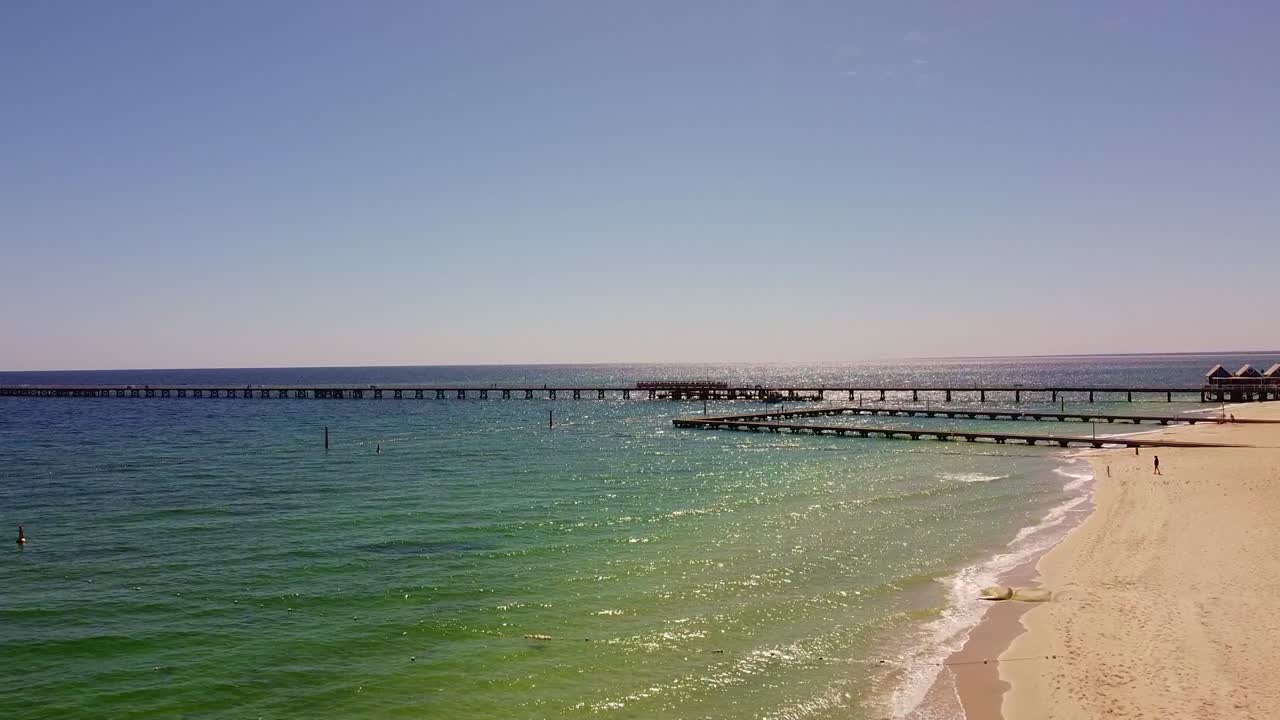 Long Pier Extending into the Ocean from a Sandy Beach