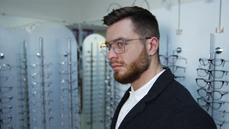 man trying eyeglasses in optics store. portrait of handsome young man trying glasses at optical store